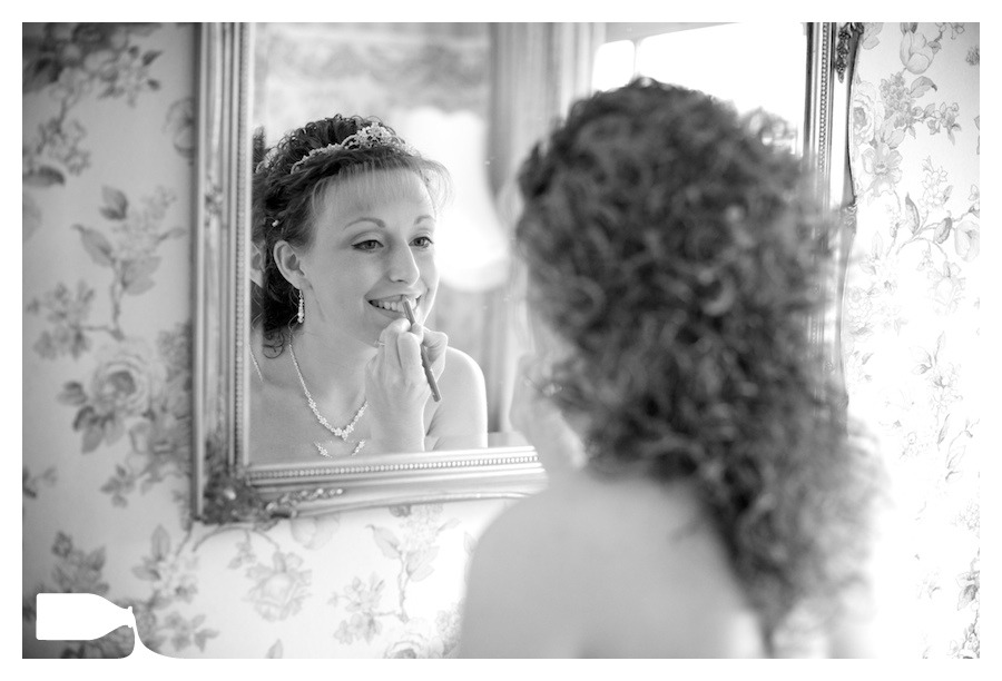 bride putting on makeup on wedding morning